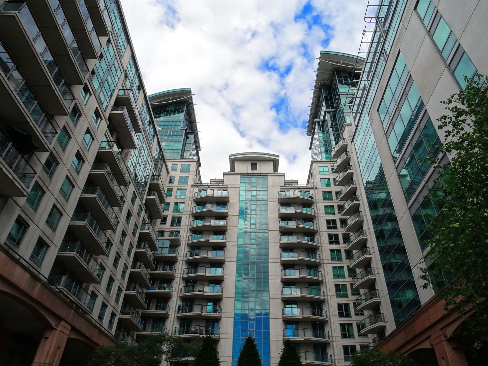 Low angle view of modern glass skyscrapers with a blue sky backdrop, highlighting architectural design. — Find out if Louisia
